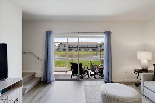 living room featuring a water view and light wood-type flooring