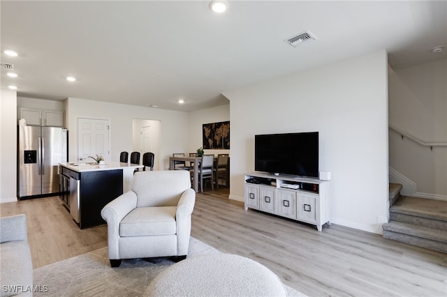 living room featuring sink and light wood-type flooring