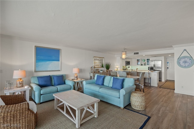 living room with crown molding and light wood-type flooring