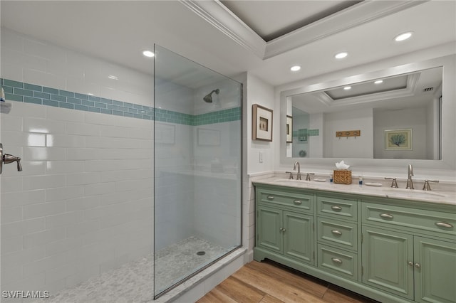 bathroom with wood-type flooring, a tile shower, vanity, and a tray ceiling