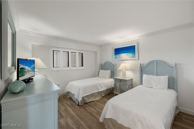 bedroom featuring crown molding and light hardwood / wood-style flooring