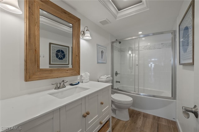 full bathroom with vanity, wood-type flooring, shower / bath combination with glass door, and toilet