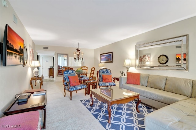 carpeted living room with a notable chandelier