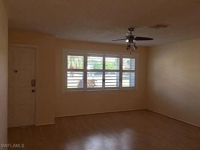 unfurnished room featuring wood-type flooring, a textured ceiling, and ceiling fan