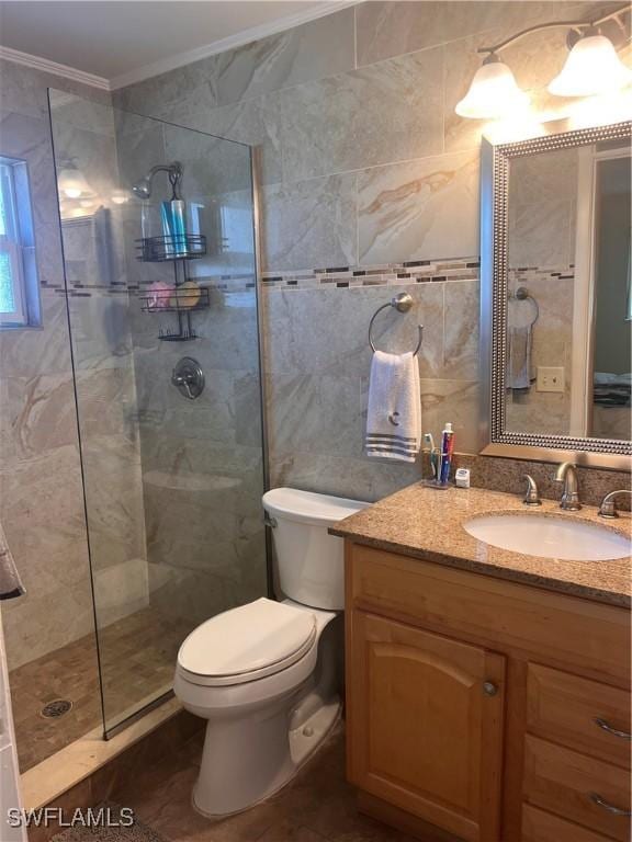 bathroom with crown molding, tiled shower, vanity, and tile walls