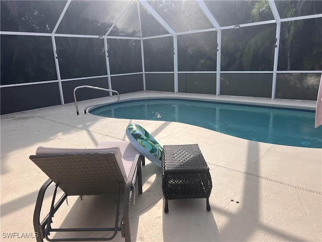 view of swimming pool featuring a patio and a lanai