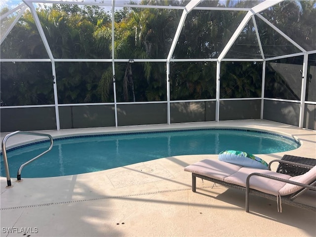 view of swimming pool featuring a patio area and glass enclosure