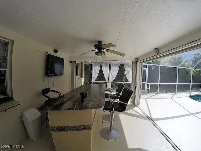 unfurnished sunroom featuring ceiling fan