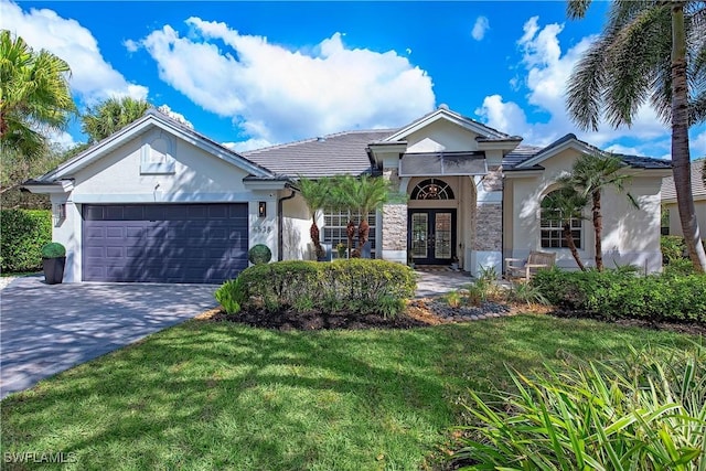 ranch-style home featuring decorative driveway, an attached garage, french doors, and stucco siding