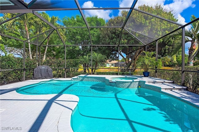 view of swimming pool featuring a patio, a lanai, and a pool with connected hot tub