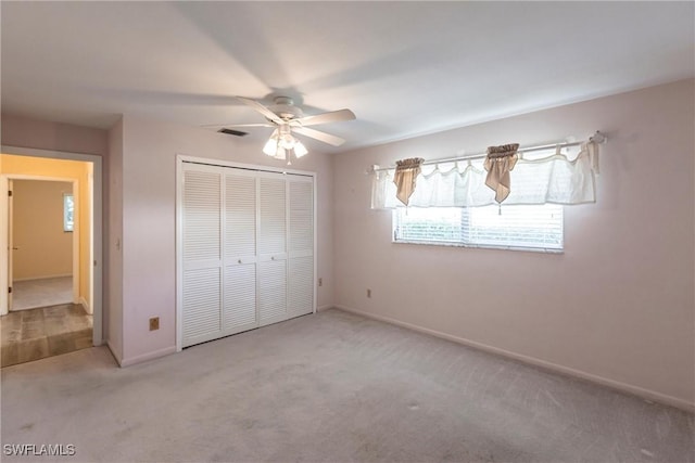 unfurnished bedroom with light carpet, a closet, and ceiling fan