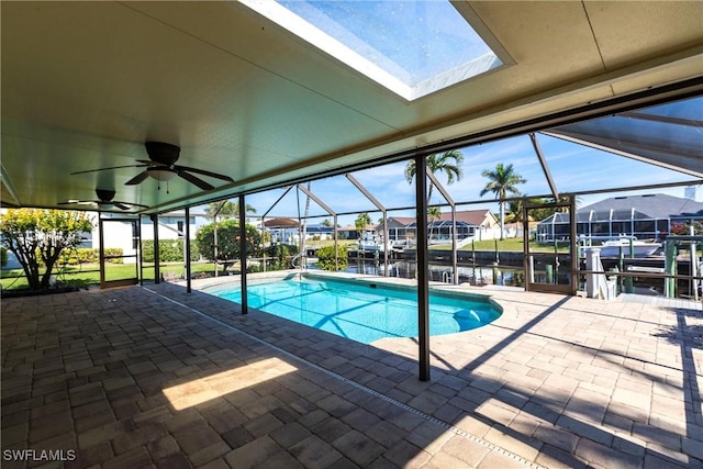 view of pool with a water view, ceiling fan, a lanai, and a patio