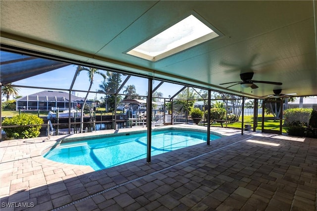 view of swimming pool featuring a water view, ceiling fan, a lanai, and a patio area