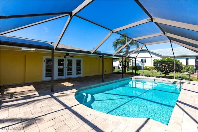 view of pool featuring a patio, glass enclosure, ceiling fan, and french doors