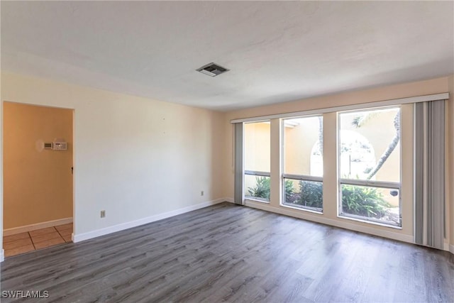 unfurnished room with dark wood-type flooring