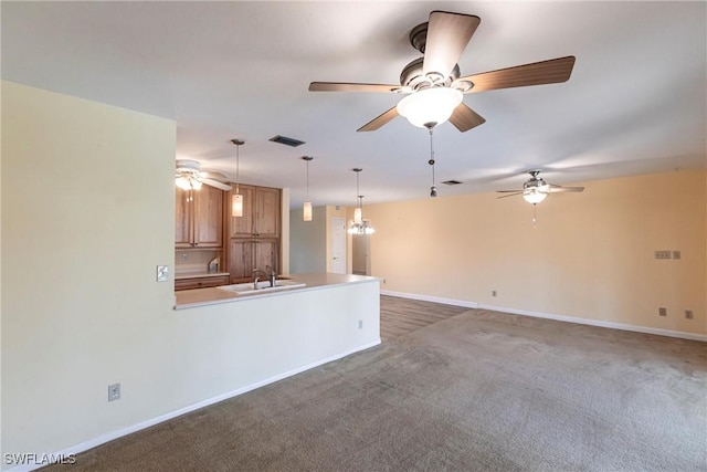 unfurnished living room featuring ceiling fan, sink, and dark colored carpet