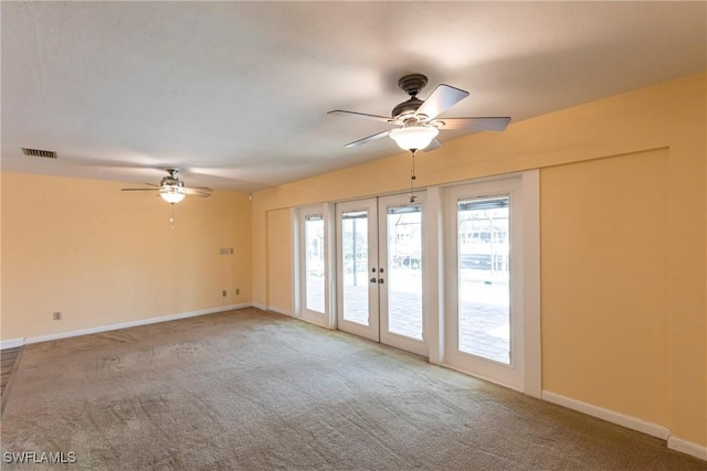 carpeted empty room with plenty of natural light, french doors, and ceiling fan