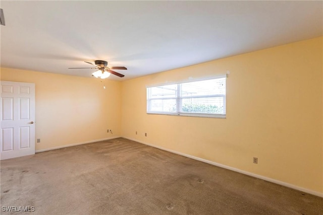 carpeted spare room with ceiling fan