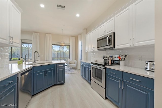 10090 Valiant Ct Unit 202, Miromar Lakes, FL 33913 - kitchen featuring blue cabinetry, a sink, appliances with stainless steel finishes, and visible vents