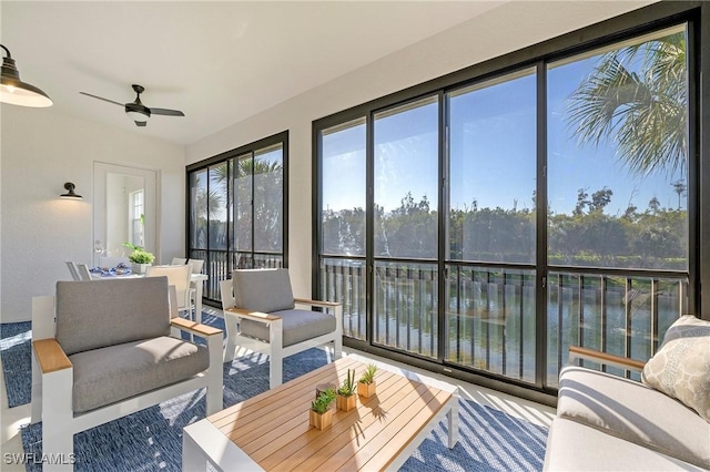 sunroom with a water view and a ceiling fan