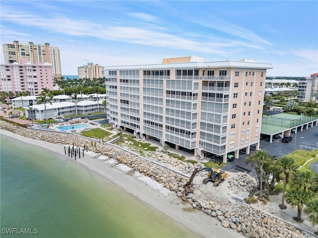 view of property with a water view and a beach view