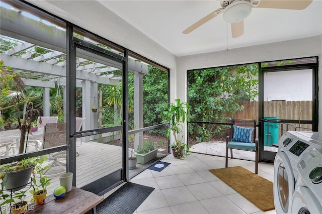 sunroom / solarium featuring ceiling fan and separate washer and dryer