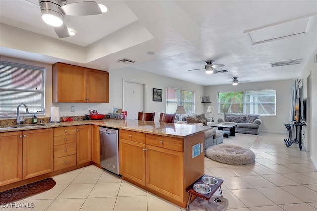 kitchen featuring sink, light stone counters, light tile patterned flooring, stainless steel dishwasher, and kitchen peninsula