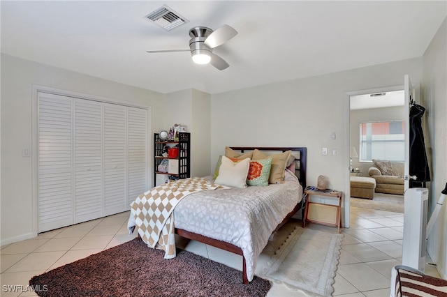 bedroom with light tile patterned floors, a closet, and ceiling fan