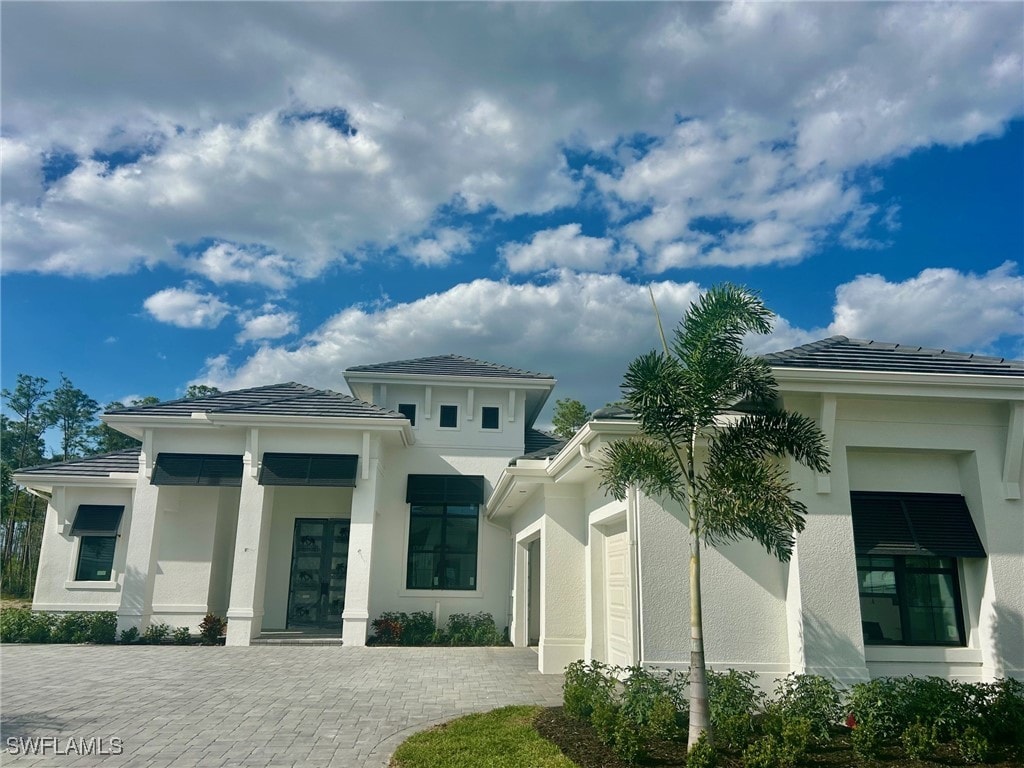 view of front of property with a garage, decorative driveway, and stucco siding