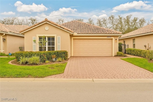 20037 Serene Meadow Ln, Estero, FL 33928 - mediterranean / spanish-style home featuring decorative driveway, a garage, stucco siding, a front yard, and a tile roof