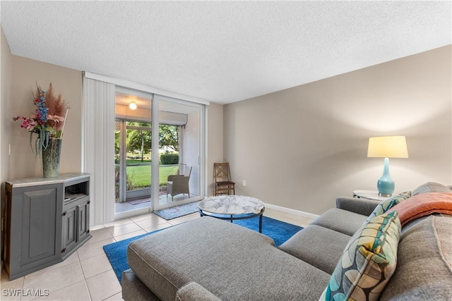 living room featuring light tile patterned floors, a textured ceiling, and a wall of windows