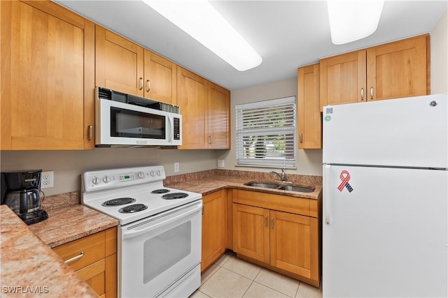 kitchen with light stone countertops, sink, light tile patterned floors, and white appliances