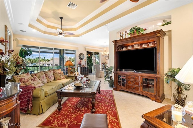 tiled living room featuring crown molding, a raised ceiling, and ceiling fan with notable chandelier