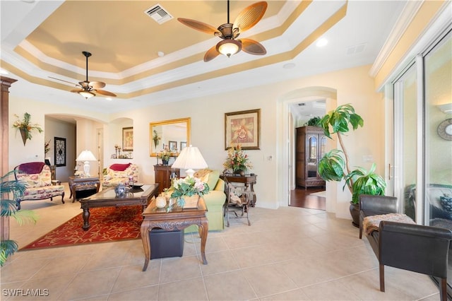 living room with ornamental molding, a raised ceiling, ceiling fan, and light tile patterned flooring