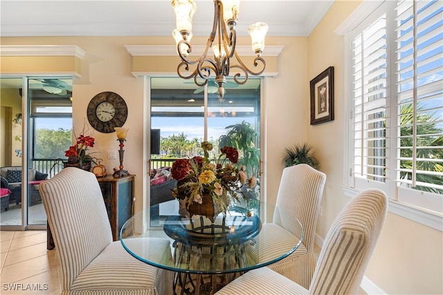 dining area featuring tile patterned flooring, ornamental molding, and a chandelier