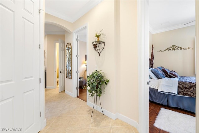 corridor with crown molding and light tile patterned flooring