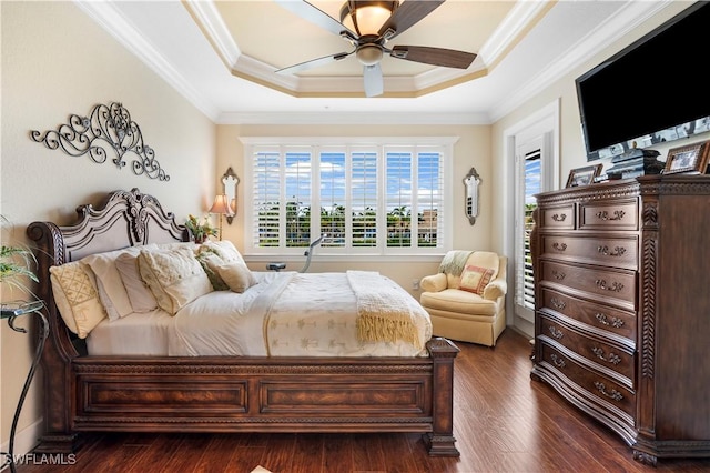 bedroom featuring crown molding, dark wood-type flooring, a raised ceiling, and ceiling fan