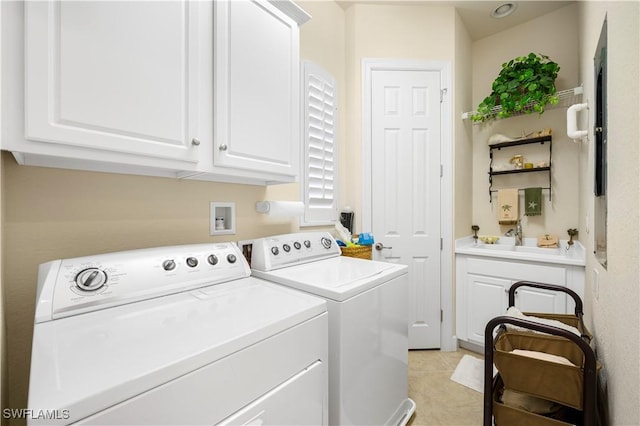 laundry room featuring light tile patterned floors, sink, washing machine and dryer, and cabinets