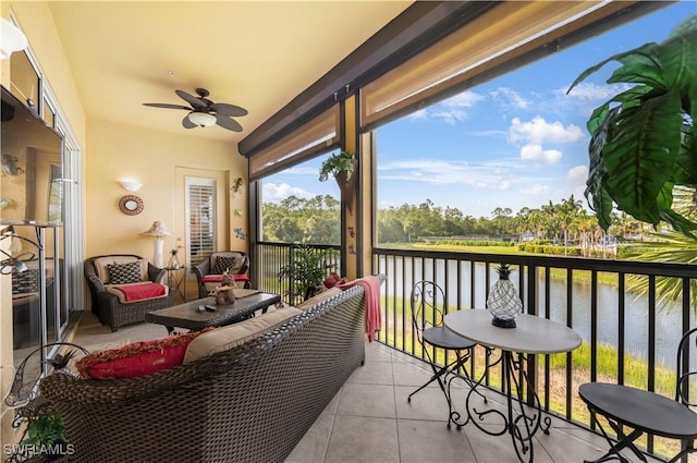 sunroom featuring a water view and ceiling fan