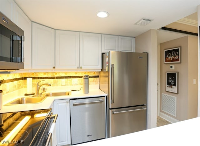 kitchen featuring tasteful backsplash, stainless steel appliances, sink, and white cabinets