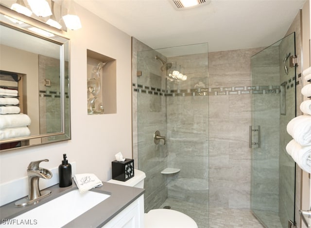 bathroom featuring an enclosed shower, vanity, and toilet