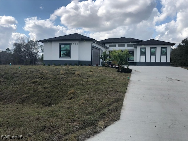 view of front of home featuring a garage and a front lawn