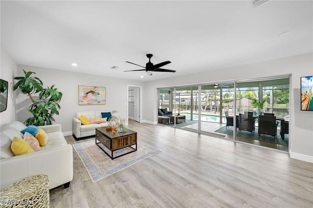 living room featuring ceiling fan and light hardwood / wood-style flooring