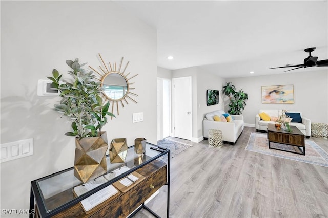 living room with ceiling fan and light wood-type flooring