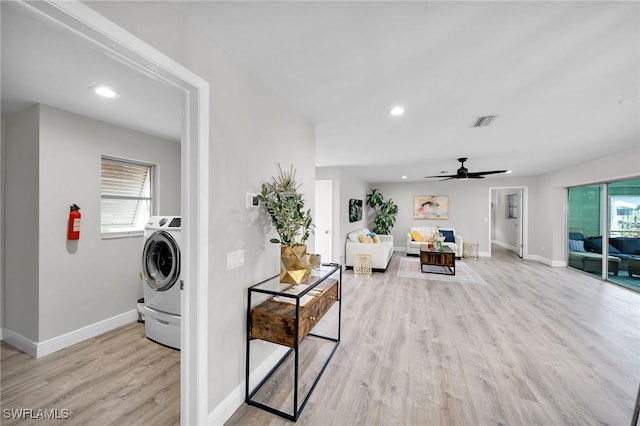 clothes washing area featuring washer / clothes dryer, ceiling fan, and light wood-type flooring