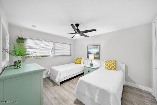 bedroom with ceiling fan, light wood-type flooring, and a closet