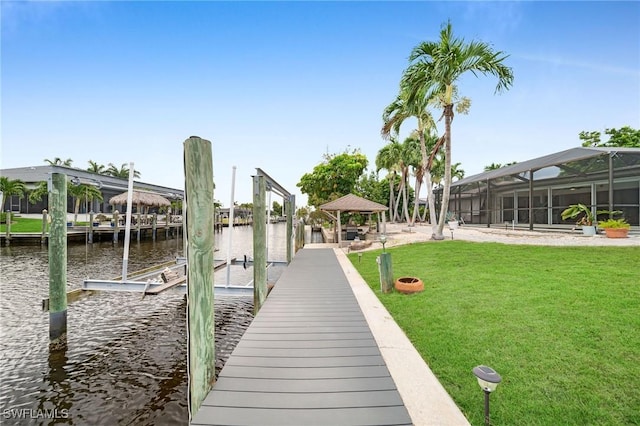 view of dock with a water view, a gazebo, and a lawn