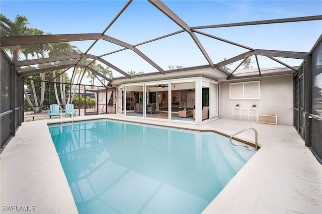 view of pool featuring an outdoor living space, a patio area, ceiling fan, and glass enclosure