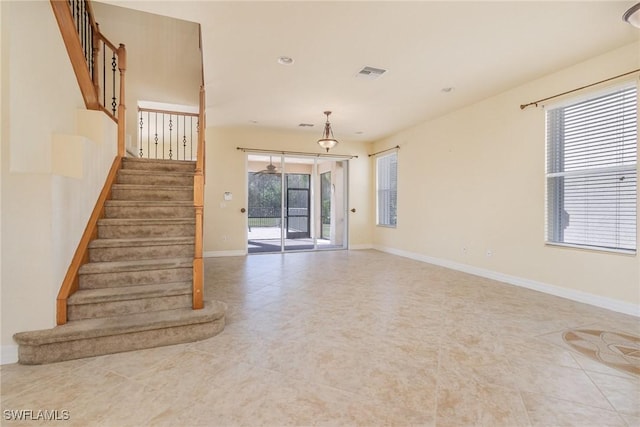 interior space with baseboards, visible vents, tile patterned floors, and stairs