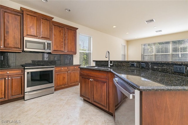 kitchen with backsplash, visible vents, a sink, light tile patterned flooring, and appliances with stainless steel finishes